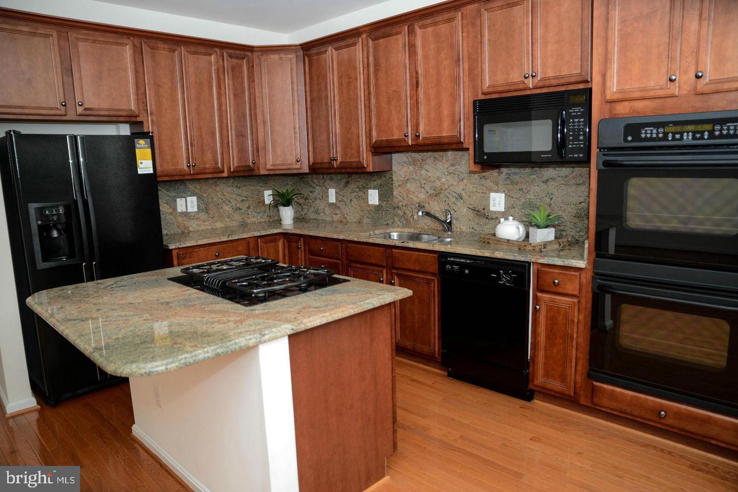 41898 Cinnabar Aldie, VA 20105 - Photo 7 of 33 a kitchen with stainless steel appliances a stove a microwave a sink and cabinets