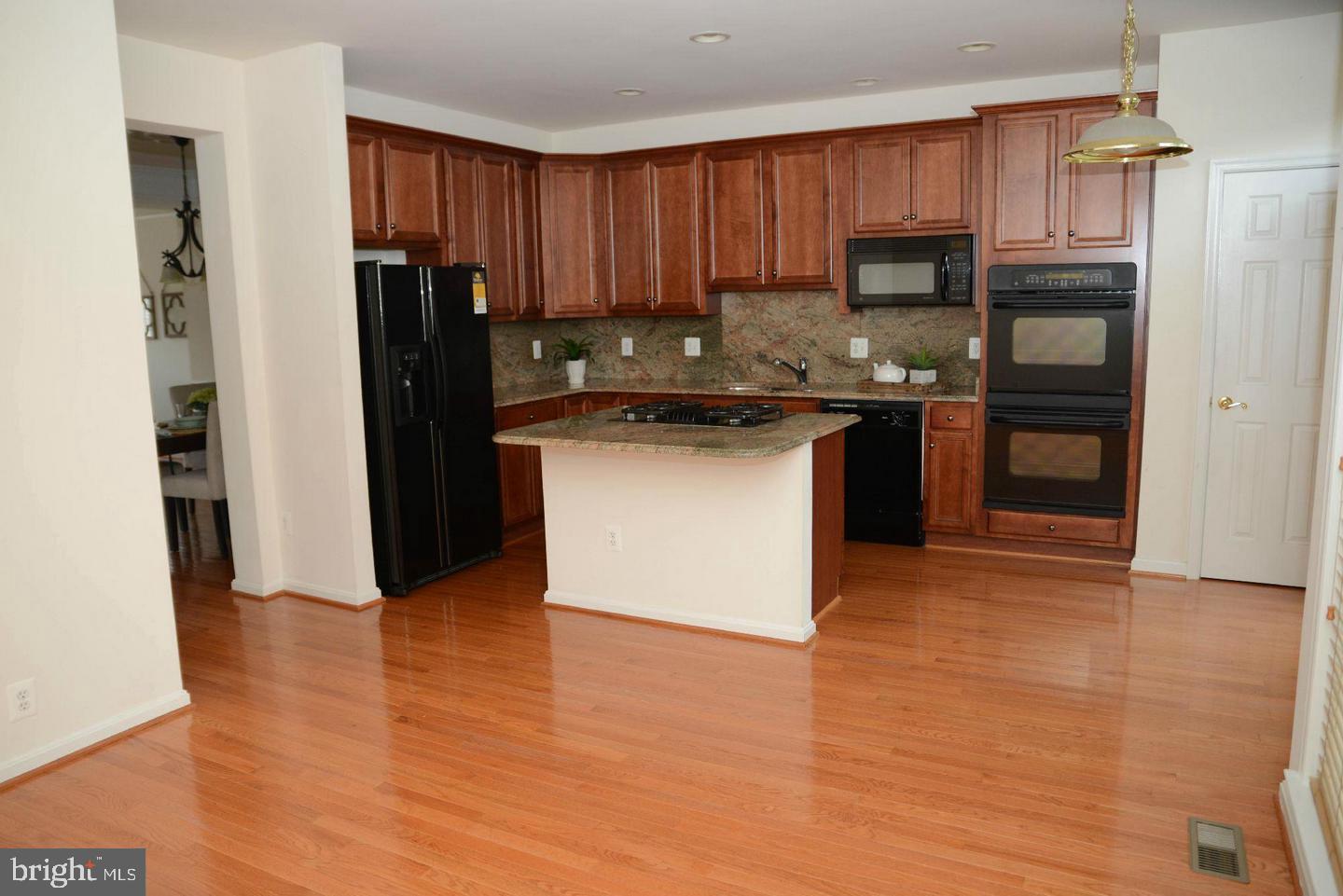 41898 Cinnabar Aldie, VA 20105 - Photo 8 of 33 a kitchen with granite countertop a refrigerator and a stove top oven