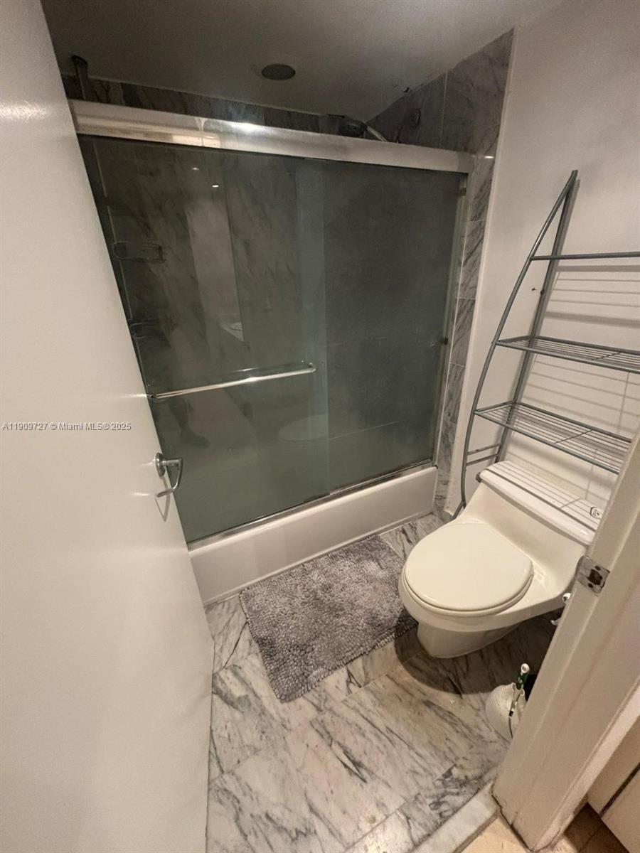 8911 Collins Avenue, Unit 303 Surfside, FL 33154 - Photo 16 of 16 a bathroom with a toilet and a shower