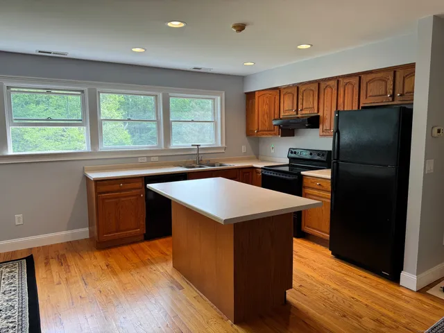 a kitchen with stainless steel appliances granite countertop a refrigerator a sink a stove and island