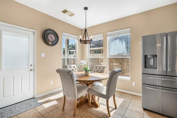 a dining room with furniture a kitchen and chandelier