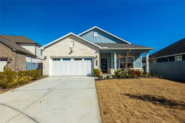 a front view of a house with a yard outdoor seating and garage