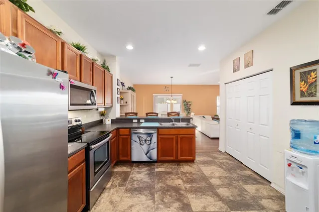 a kitchen with stainless steel appliances granite countertop a stove refrigerator and sink
