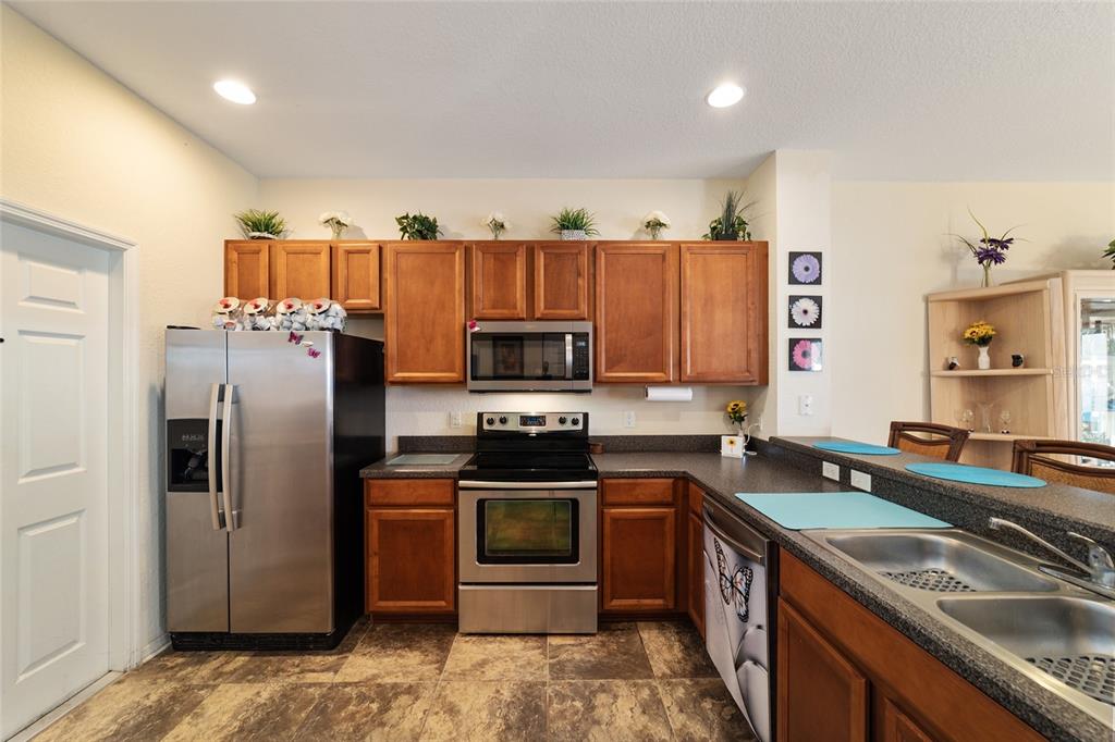 12312 Northeast 48th Loop Oxford, FL 34484 - Photo 32 of 54 a kitchen with stainless steel appliances granite countertop a stove refrigerator and sink