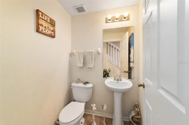 a spacious bathroom with a toilet a sink and a mirror
