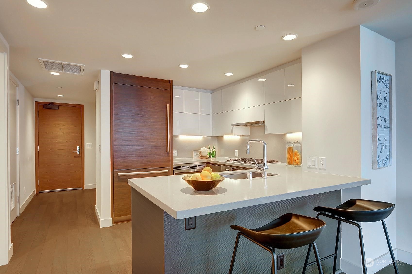583 Battery Street, Unit 2708N Seattle, WA 98121 - Photo 13 of 30 a kitchen with a sink cabinets and chairs