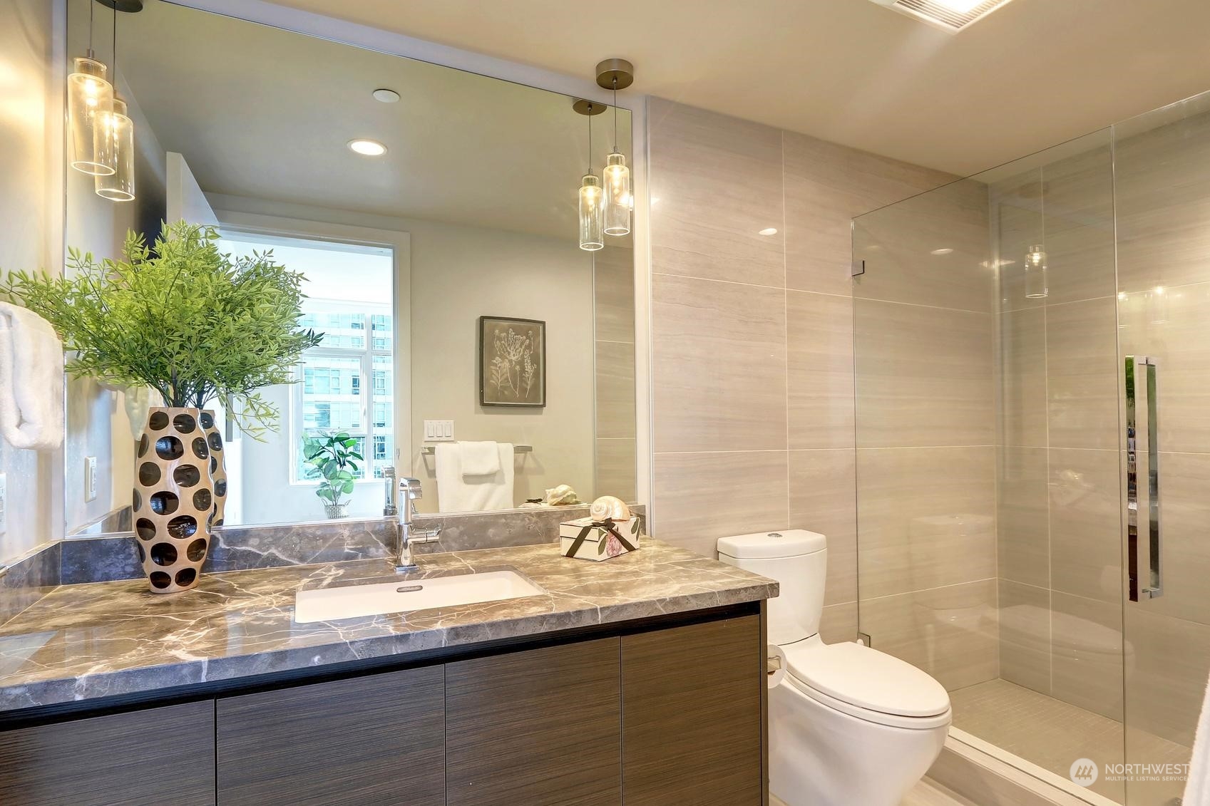 583 Battery Street, Unit 2708N Seattle, WA 98121 - Photo 17 of 30 a bathroom with a granite countertop sink a toilet a mirror and shower