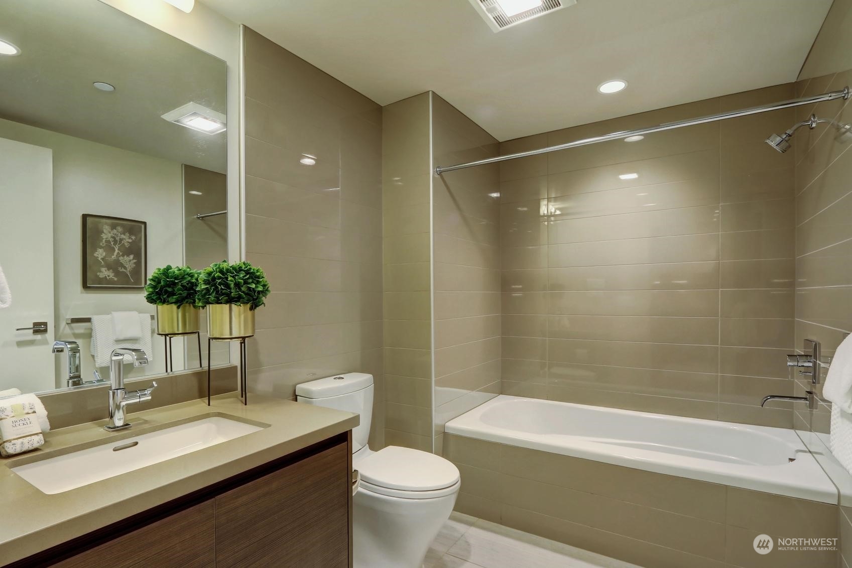 583 Battery Street, Unit 2708N Seattle, WA 98121 - Photo 19 of 30 a bathroom with a granite countertop sink a toilet a mirror a bathtub and shower