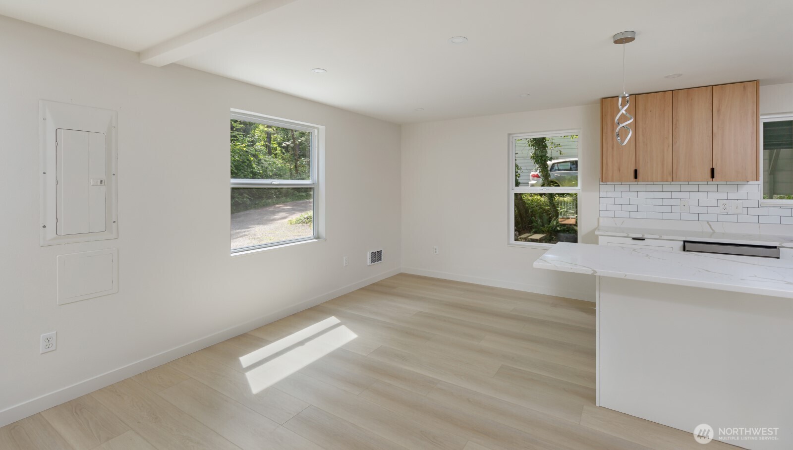 7605 Northeast Hidden Cove Road Bainbridge Island, WA 98110 - Photo 28 of 36 a view of an empty room with window and wooden floor