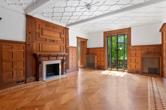 a view of an empty room with a fireplace and a window