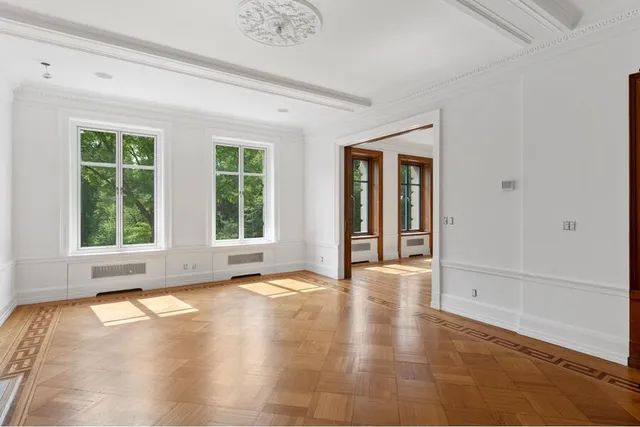 a view of a hallway with wooden floor and windows