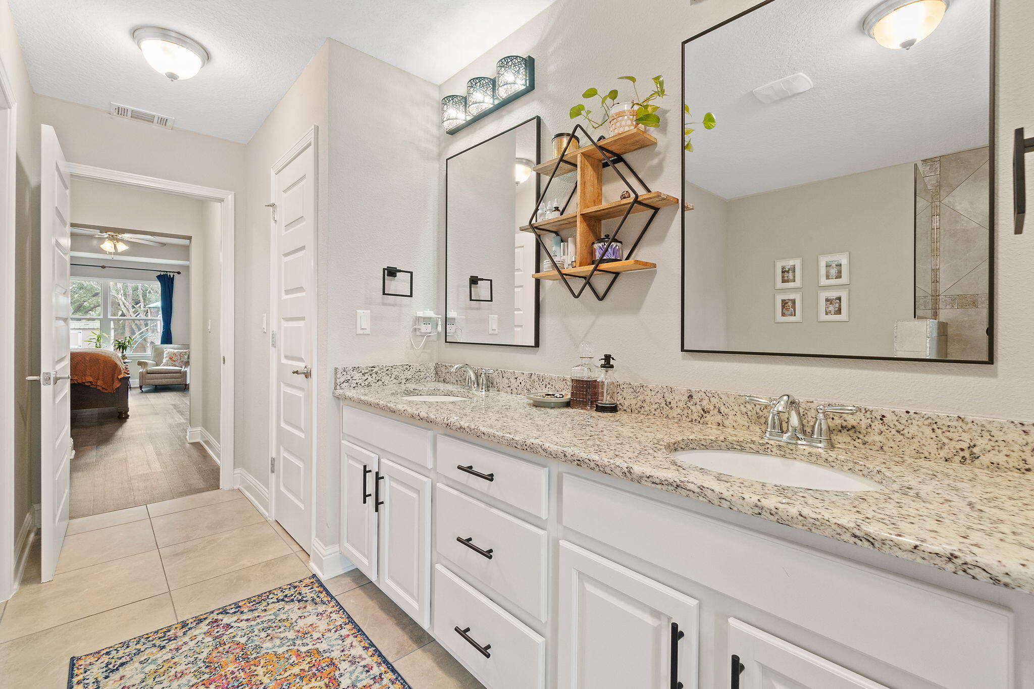 6955 Snug Waters Road Navarre, FL 32566 - Photo 38 of 45 a bathroom with double vanity sinks and a mirror