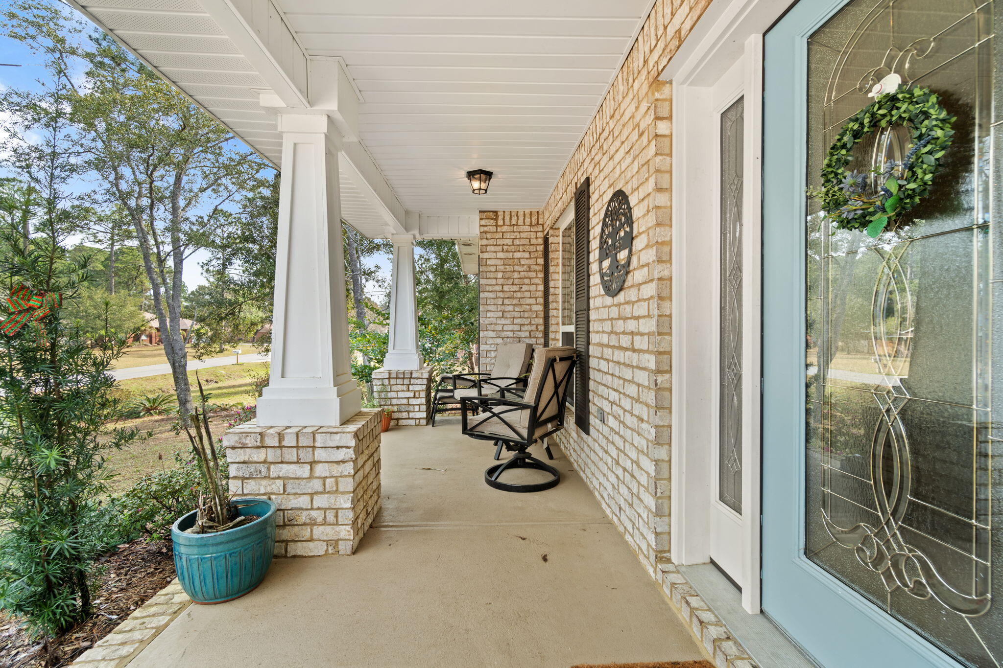 6955 Snug Waters Road Navarre, FL 32566 - Photo 4 of 45 a view of a balcony with chairs and potted plants