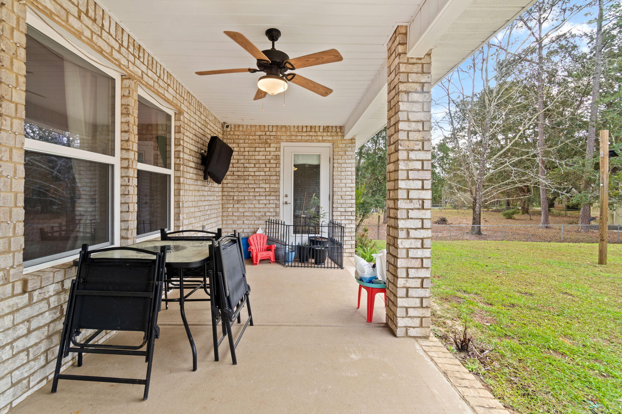 6955 Snug Waters Road Navarre, FL 32566 - Photo 41 of 45 a view of a porch with furniture and a yard