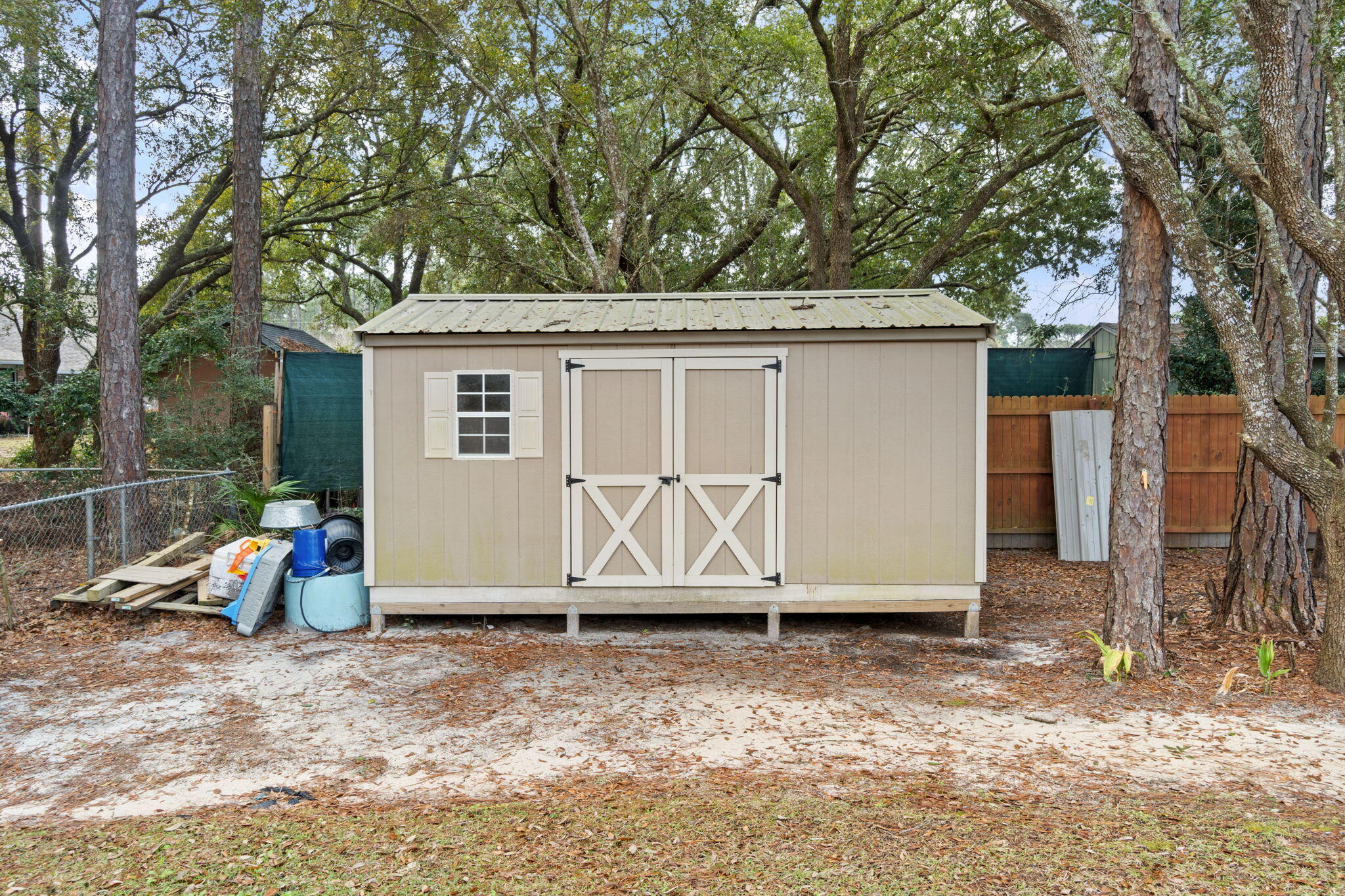6955 Snug Waters Road Navarre, FL 32566 - Photo 45 of 45 a view of a barn in the backyard with large tree and wooden fence