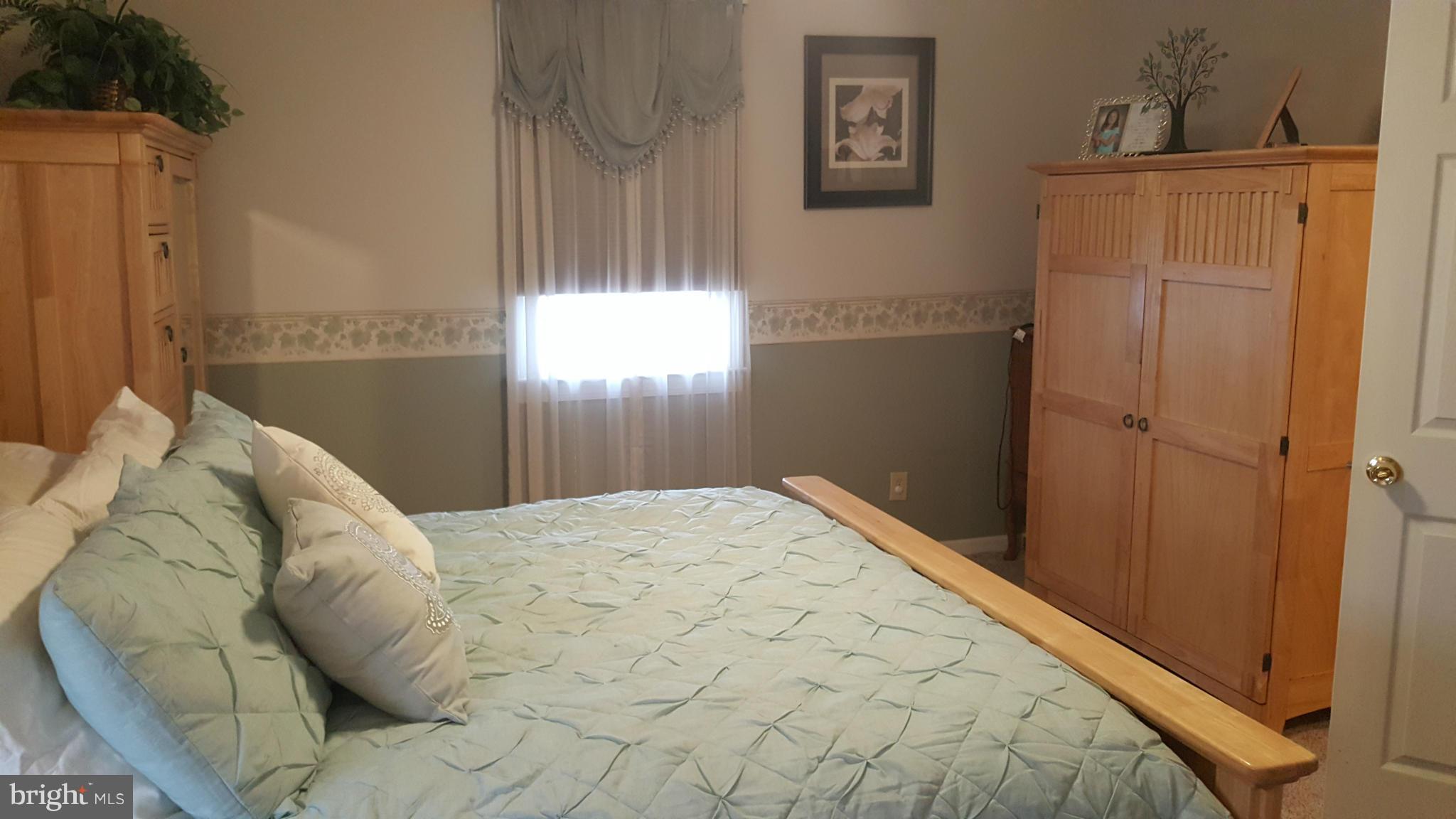 8250 Longpoint Road Baltimore, MD 21222 - Photo 15 of 30 a bed sitting in a bedroom next to a window