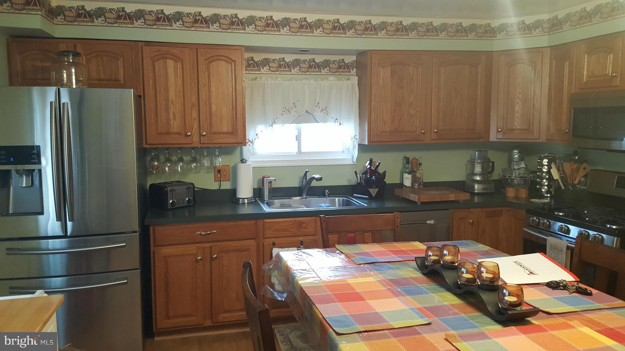 8250 Longpoint Road Baltimore, MD 21222 - Photo 3 of 30 a kitchen with granite countertop a refrigerator and a stove top oven