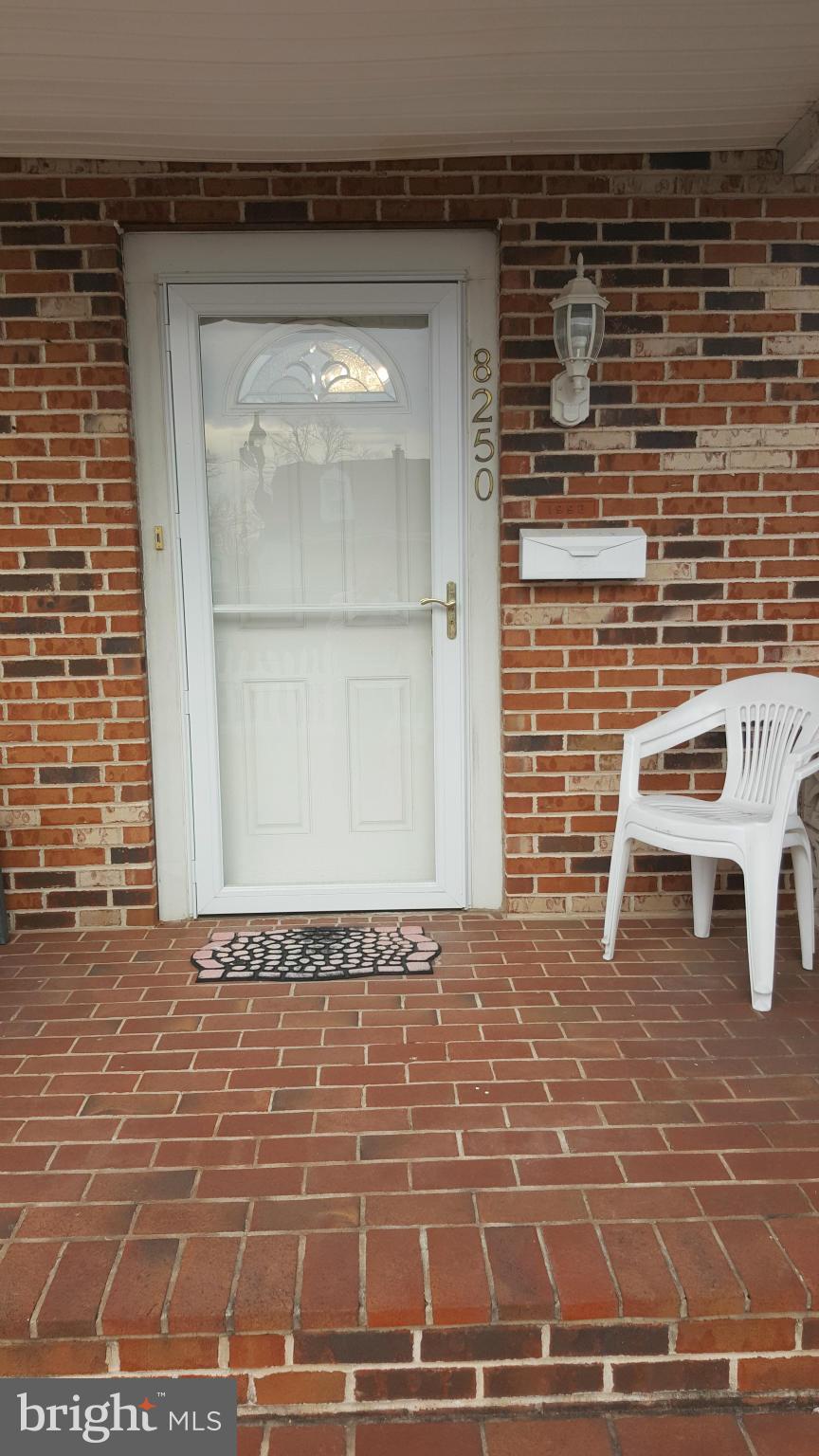 8250 Longpoint Road Baltimore, MD 21222 - Photo 29 of 30 a view of a brick wall with a bench in front of door