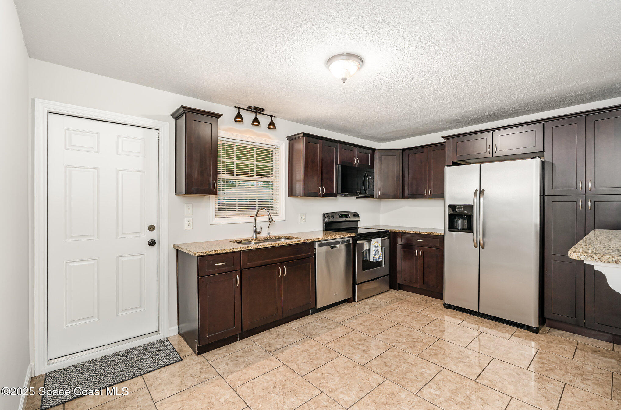 1095 Dorchester Road Palm Bay, FL 32907 - Photo 8 of 26 a kitchen with stainless steel appliances granite countertop a refrigerator and a sink