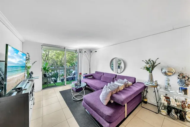 a living room with furniture a flat screen tv and a large window