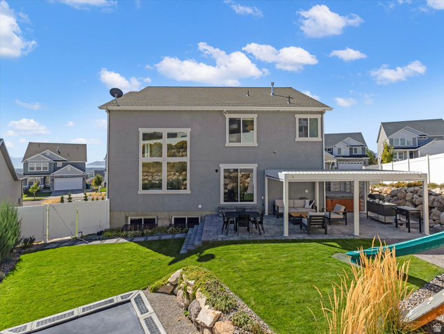 882 Spring Dew Lane Lehi, UT 84048 - Photo 22 of 46 Back of house featuring a patio, a fenced backyard, an outdoor lounge area, stucco siding, and a residential view
