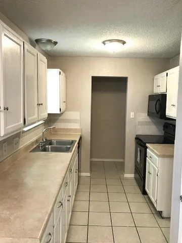 a kitchen with a sink stove and cabinets