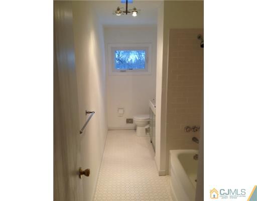 82 Princeton Road Old Bridge, NJ 08859 - Photo 5 of 6 a view of a hallway with wooden floor and a bathroom