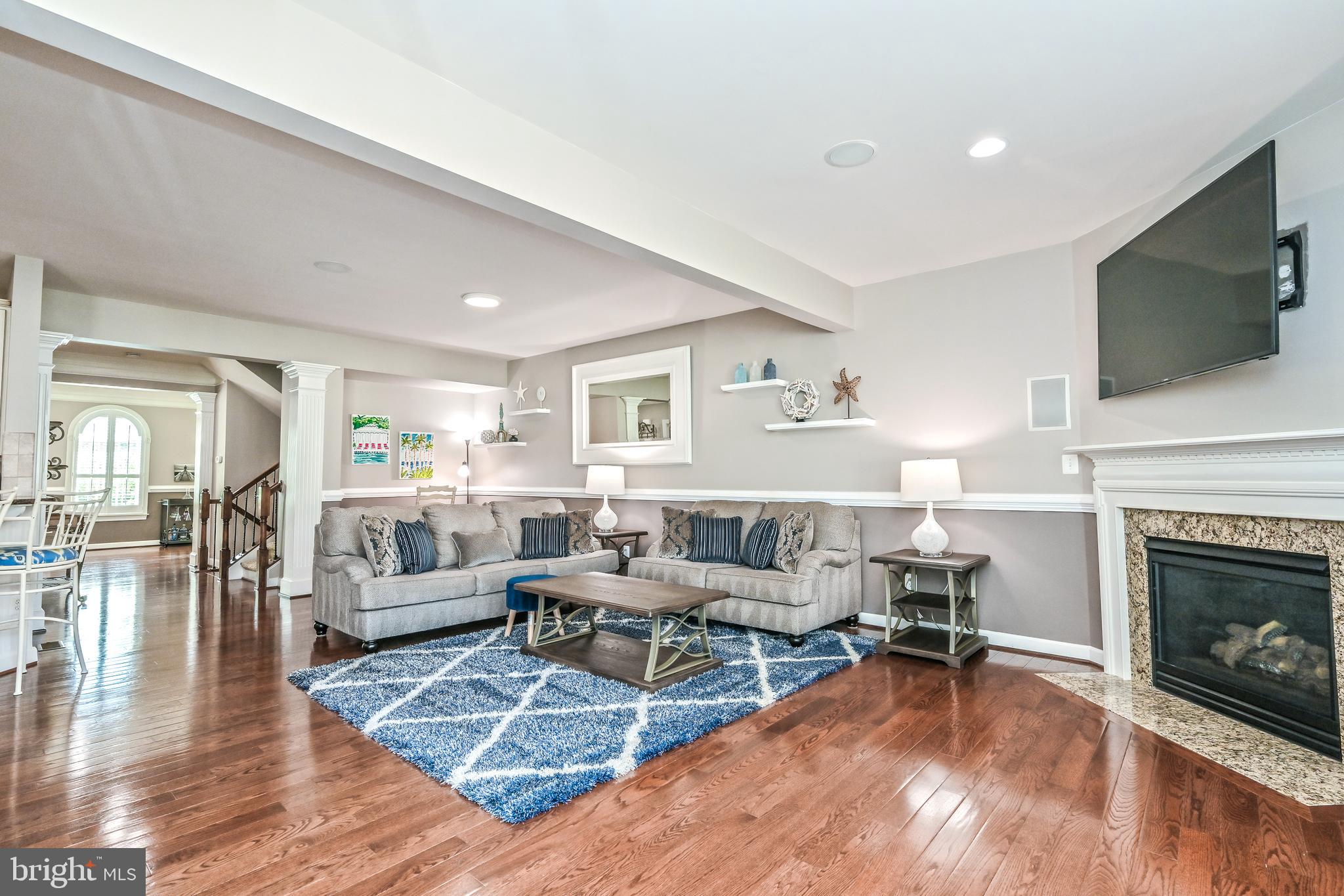 24947 Earlsford Drive Chantilly, VA 20152 - Photo 12 of 40 a living room with furniture a flat screen tv and a fireplace