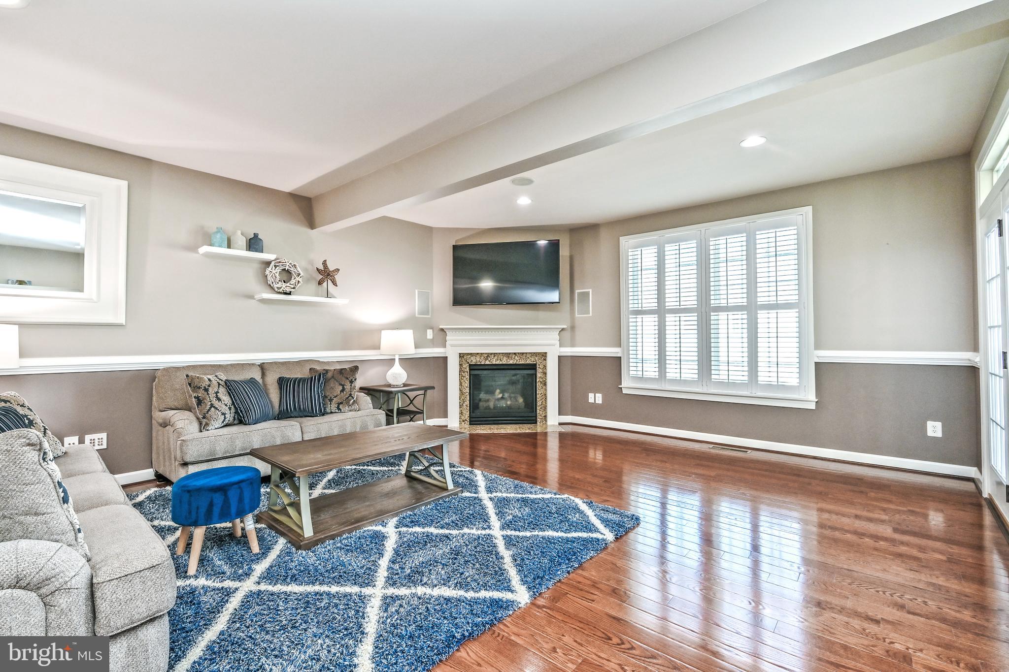 24947 Earlsford Drive Chantilly, VA 20152 - Photo 13 of 40 a living room with furniture a flat screen tv and a fireplace