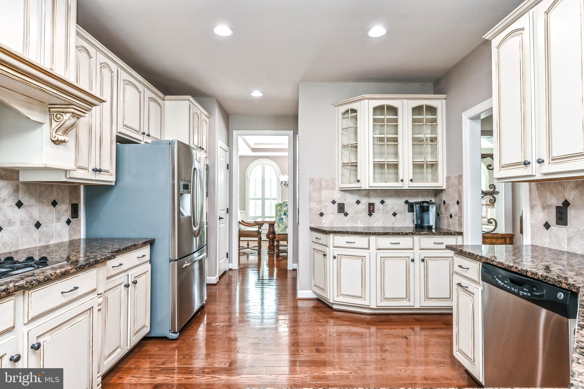 24947 Earlsford Drive Chantilly, VA 20152 - Photo 21 of 40 a large kitchen with stainless steel appliances granite countertop a stove a sink dishwasher a refrigerator and white cabinets with wooden floor
