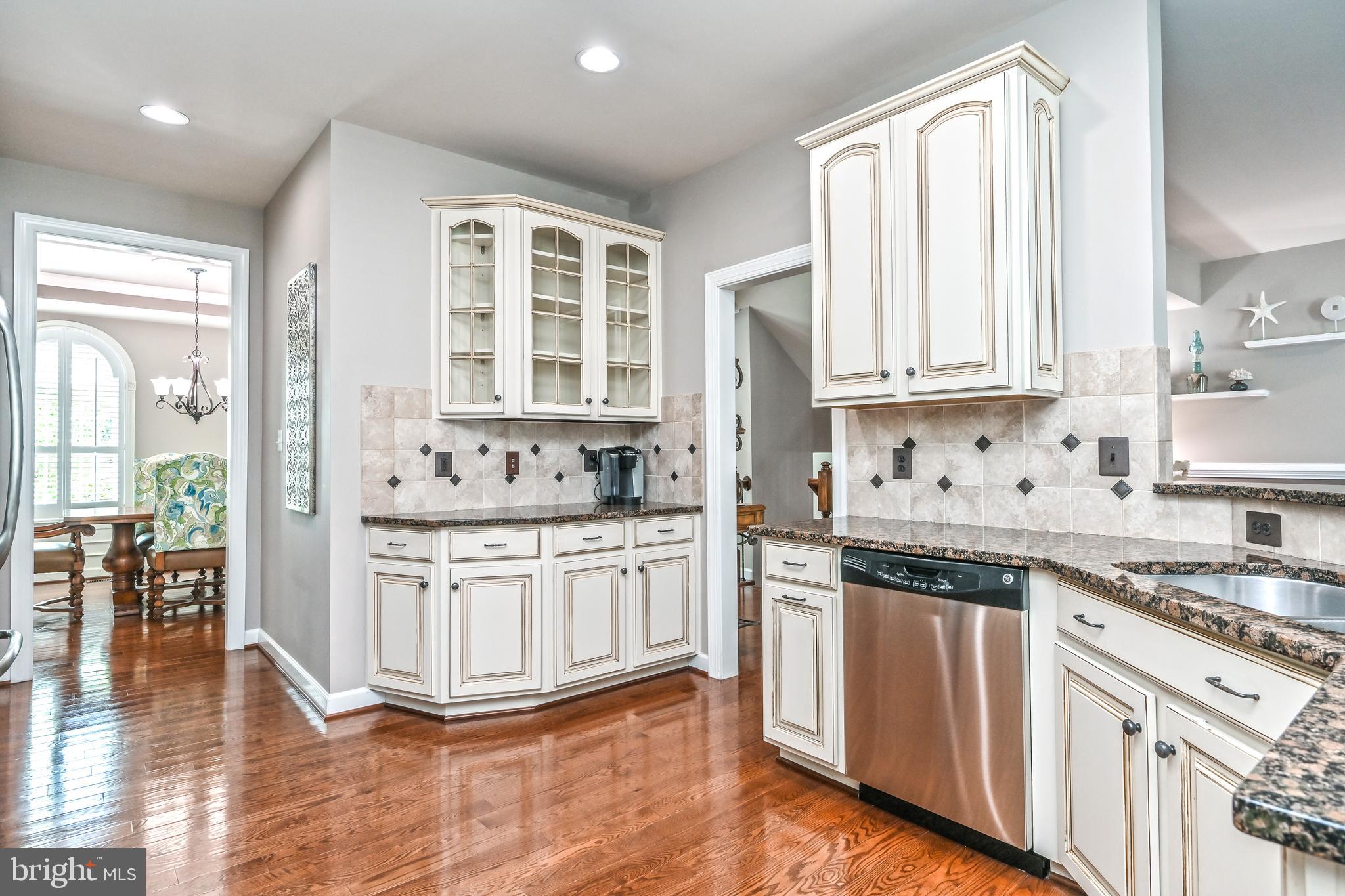 24947 Earlsford Drive Chantilly, VA 20152 - Photo 22 of 40 a kitchen with stainless steel appliances granite countertop a stove a sink and white cabinets with wooden floor