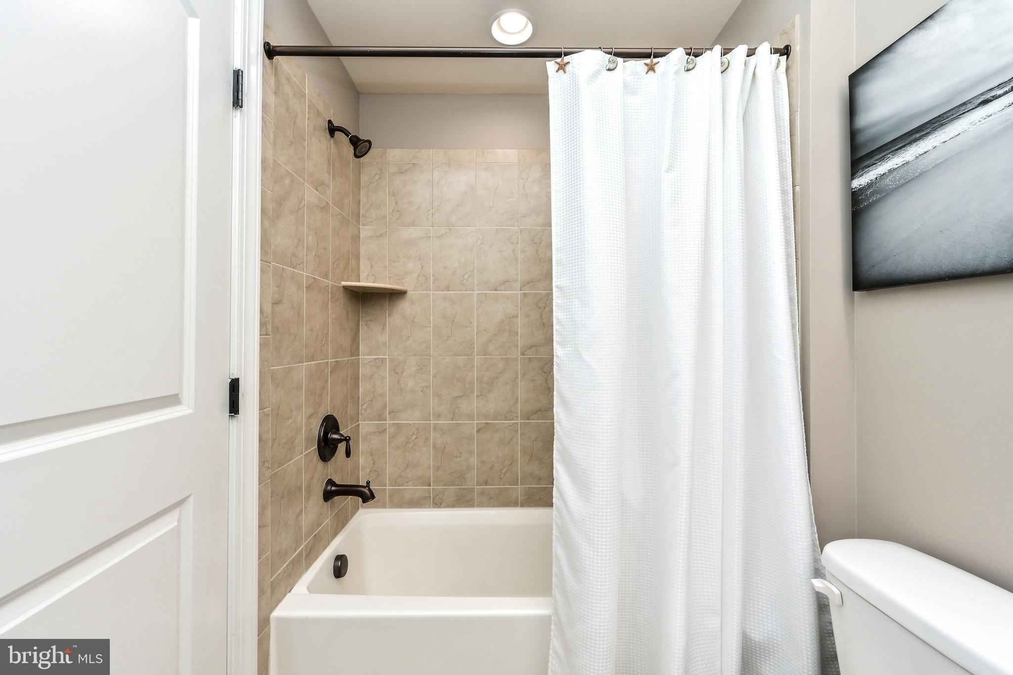 24947 Earlsford Drive Chantilly, VA 20152 - Photo 9 of 40 a bathroom with a shower curtain and a toilet