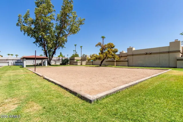 a view of a swimming pool with a table and chairs under an umbrella
