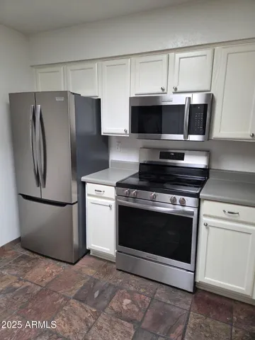 a kitchen with a refrigerator and a stove top oven