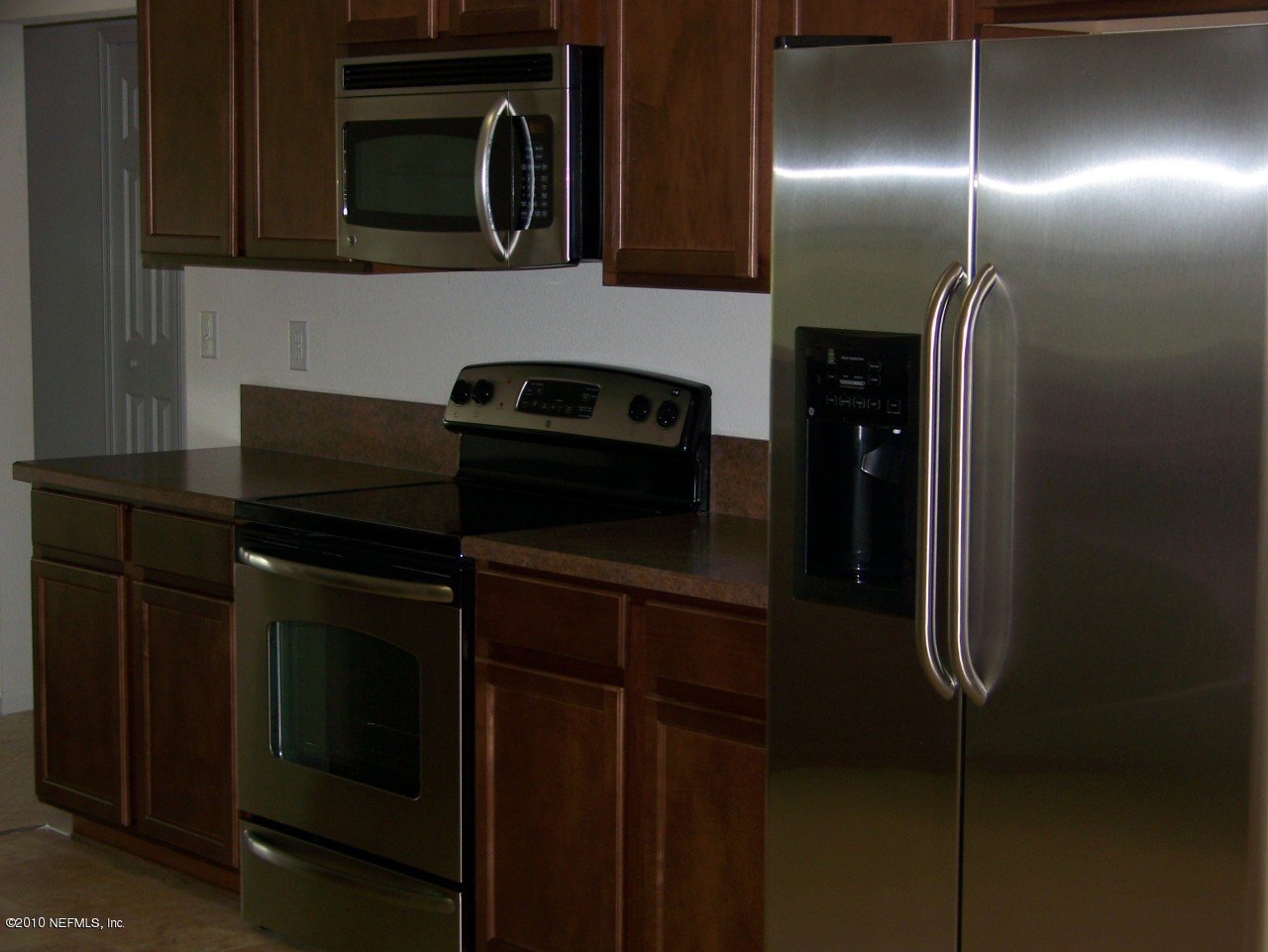 1867 Reed Valley Way, Unit AZALEA RIDGE LOT 133 Middleburg, FL 32068 - Photo 15 of 17 a kitchen with a refrigerator and microwave