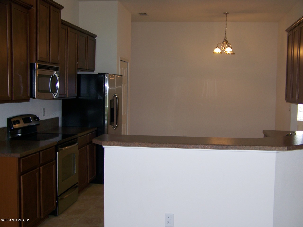 1867 Reed Valley Way, Unit AZALEA RIDGE LOT 133 Middleburg, FL 32068 - Photo 3 of 17 a kitchen with a refrigerator and a stove top oven