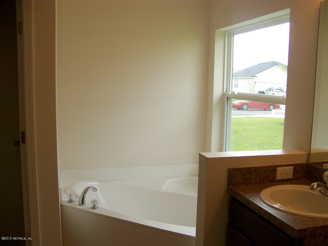 1867 Reed Valley Way, Unit AZALEA RIDGE LOT 133 Middleburg, FL 32068 - Photo 8 of 17 a bathroom with a granite countertop sink and a bathtub