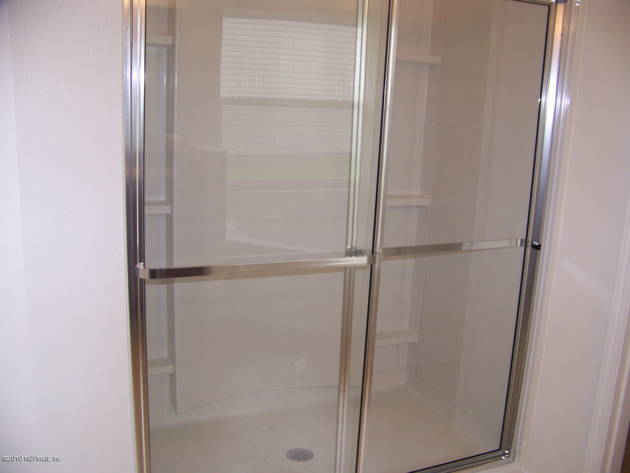 1867 Reed Valley Way, Unit AZALEA RIDGE LOT 133 Middleburg, FL 32068 - Photo 9 of 17 a bathroom with a glass shower door