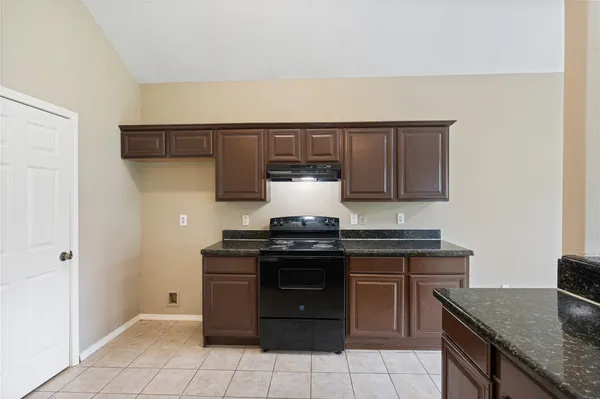 a kitchen with granite countertop a stove and a sink