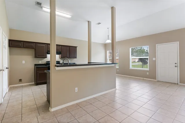 a view of kitchen with windows and refrigerator