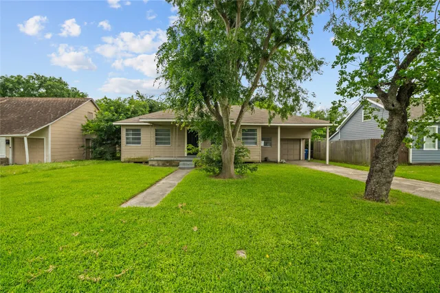a front view of house with a garden and trees