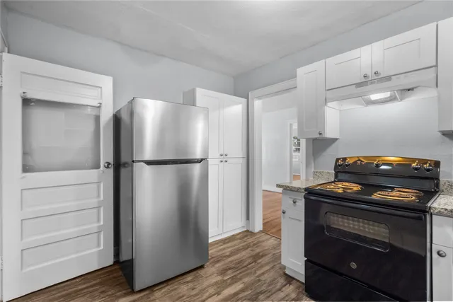 a kitchen with a refrigerator and a stove top oven