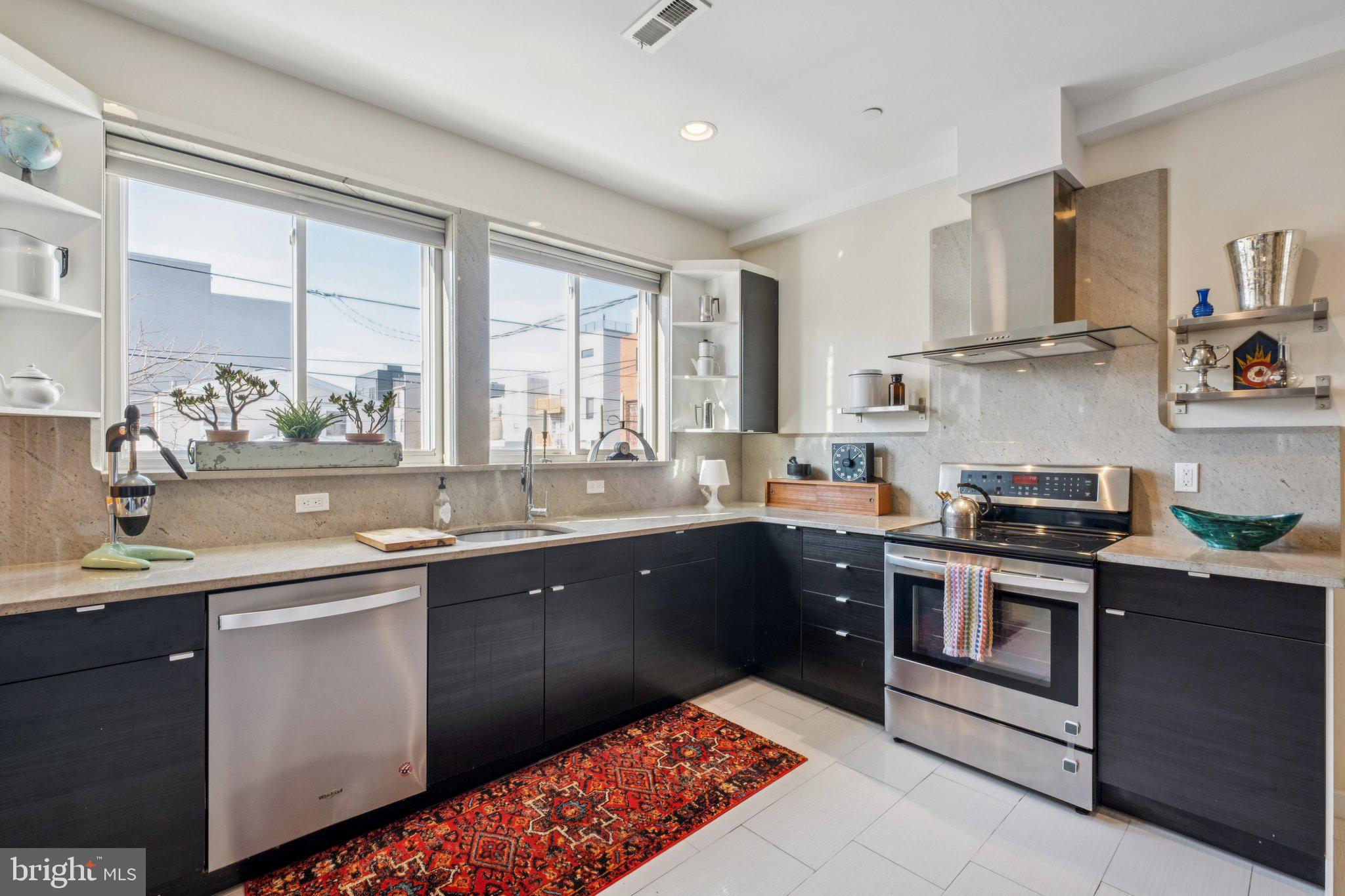 1189 South 21st Street Philadelphia, PA 19146 - Photo 6 of 30 a kitchen with stainless steel appliances granite countertop a sink and stove top oven