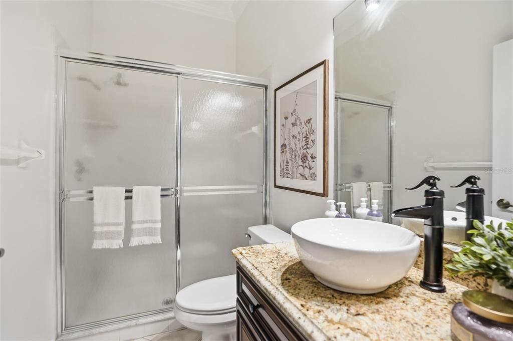 4495 Secretariat Run Spring Hill, FL 34609 - Photo 29 of 43 a bathroom with a granite countertop sink toilet a mirror and shower