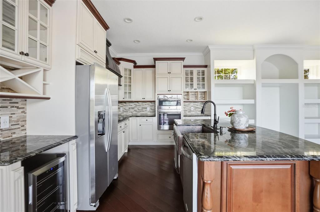 4495 Secretariat Run Spring Hill, FL 34609 - Photo 10 of 43 a kitchen with stainless steel appliances granite countertop a sink stove and refrigerator