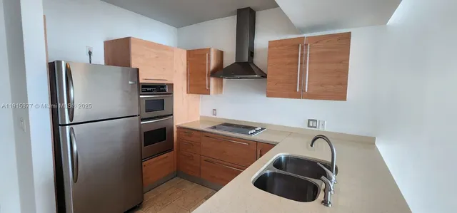 a kitchen with stainless steel appliances granite countertop a refrigerator and a sink