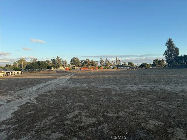 a view of a field with trees in background