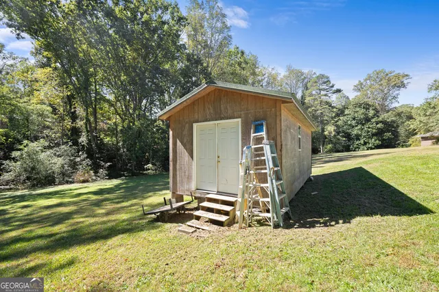 a view of a house with backyard and trees