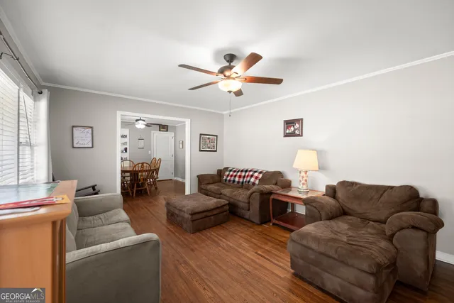 a living room with furniture ceiling fan and a window
