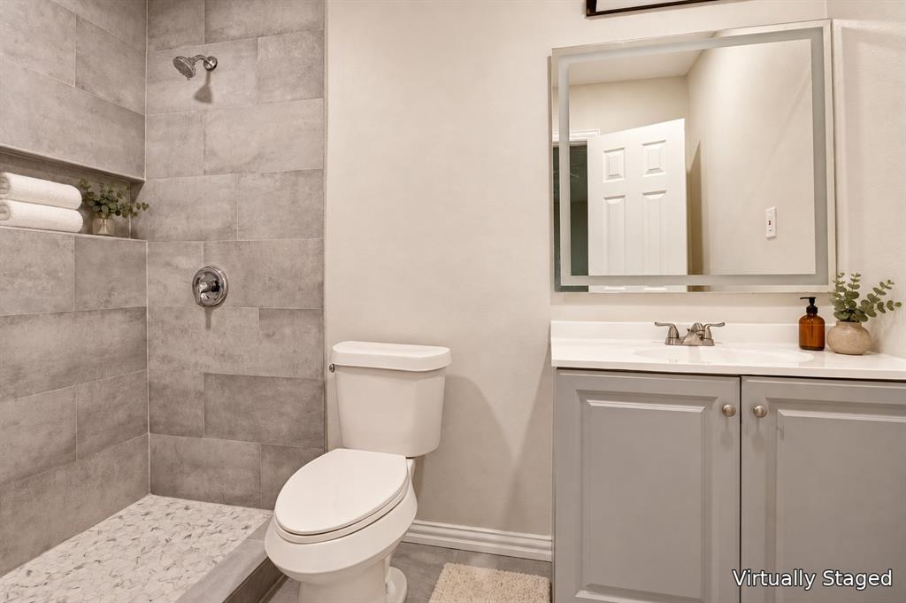 514 Chickapoo Trace Grand Prairie, TX 75051 - Photo 17 of 25 Tiled shower with a built-in niche, pebble-style shower floor, and a chrome shower fixture